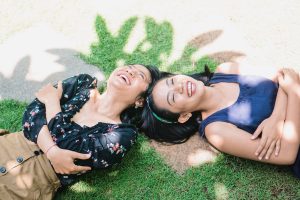 Women laughing together in grass
