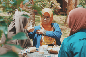 Three Indonesian women sitting at a table and talking