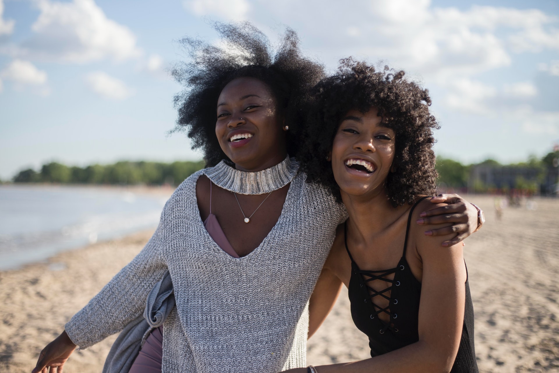 Two Black women laughing together at the beach