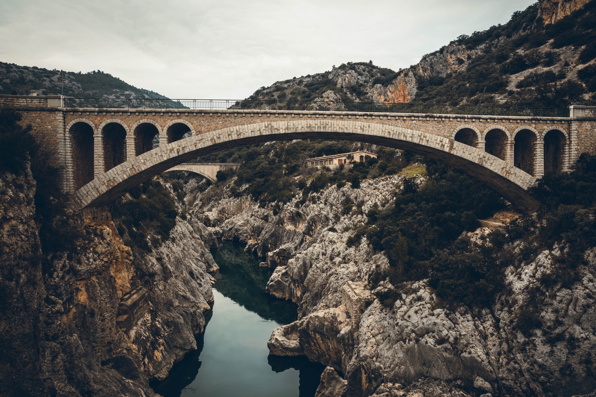 A bridge over a river in a rocky mountainous area