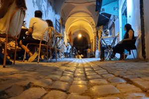 View of people dining along a cobbled road in Tunis of Medina