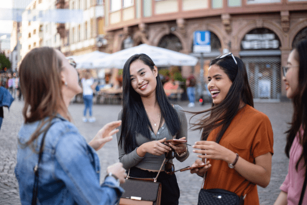 Four women travelers talking outside on a brick road