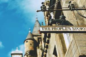 A concrete building with a sign that says "The People's Story"